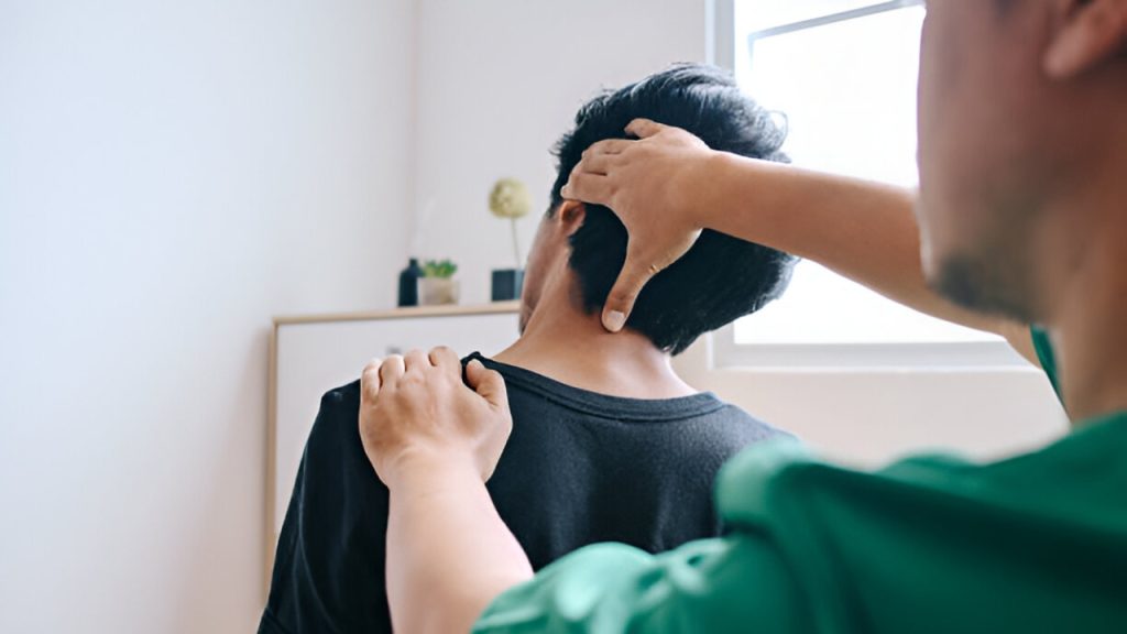 A doctor uses hands-on techniques to adjust a male patient's neck, illustrating a chiropractor near me at South Texas Spine & Joint Institute.