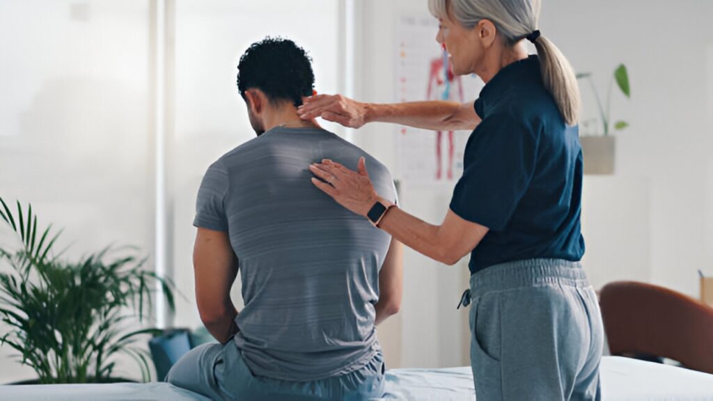A chiropractor attends to a male patient's upper back, symbolizing a chiropractor near me at South Texas Spine & Joint Institute.
